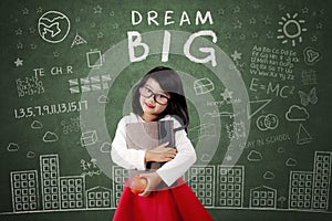 Child with Dream Big text on chalkboard