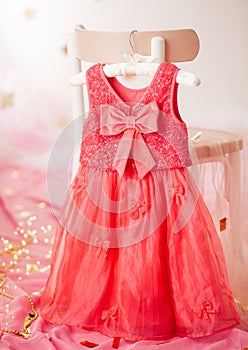 Child dress on hanger on pink background