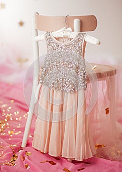 Child dress on hanger on pink background