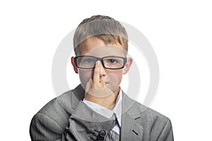 Child dressed as an adult businessman straightens glasses with his finger. Face of smart boy in glasses and adult suit isolated on