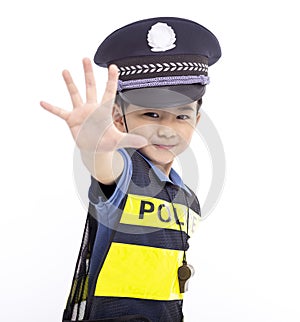 child dressed as a police officer standing and showing stop sign