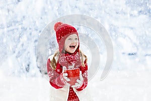 Child drinking chocolate on Christmas in snow