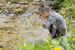 Child drinking clean river water