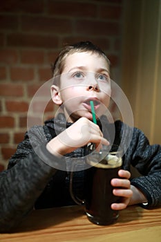 Child drinking kvass in restaurant