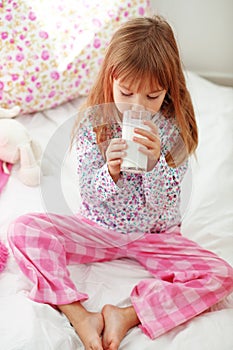 Child drinking milk in bed