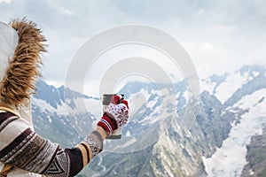 Child drinking tea in thermos in mountains