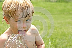 Child Drinking Water from Hose photo