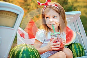 Child drinking Watermelon lemonade in jar with ice and mint as summer refreshing drink. Cold soft drinks with fruit