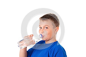Child drinks clean water from bottle isolated on white background.The boy is wearing a blue T-shirt