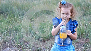 Child drinks orange fresh in the summer.