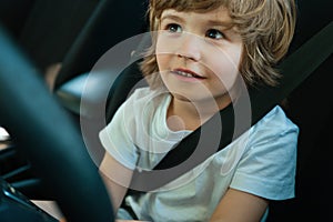 Child driver. Cute child boy while driving car as driver. Baby kid sitting in seat.