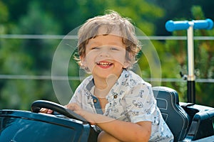 Child Driver. Cute little baby boy pretending to drive. Kid in car with hands on the wheel. Baby Driver. Little kid