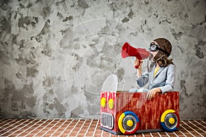 Child driving in a car made of cardboard box