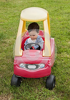 Child driving a toy car