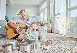 Child drummer with grandfather, guitar and music playing with pot drums in the living room at house. Happy, excited and