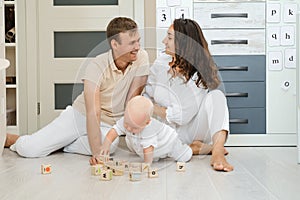 Child early development. Parents building from wooden cubes