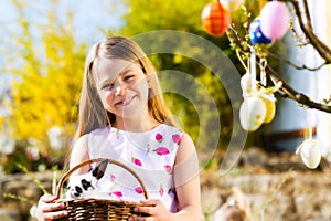 Child on Easter egg hunt with bunny