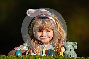 Child with easter eggs in basket outdoor. Easter egg hunt. Fynny kids portrait. Happy easter day. Kids with bunny ears