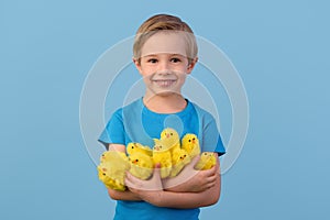 Child and Easter. Smiling blond boy, 6 years old, is holding a yellow eggs.