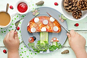 Child eat funny brunch from toast with tomato sauce, cheese and