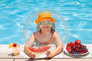 Child eat watermelon. Kid eating summer fruits on watter pool. Child in swimming pool playing in summer water. Vacation