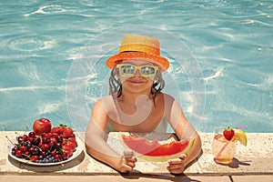 Child eat watermelon. Kid eating summer fruits on watter pool. Child in swimming pool playing in summer water. Vacation