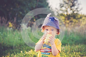 Child eating apple outdoors