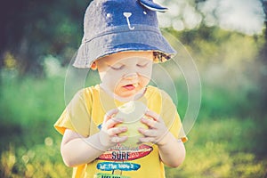 Child eating apple outdoors