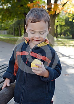 Child eating apple in park