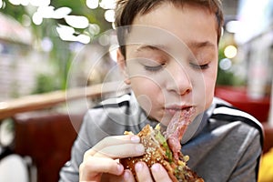 Child eating burger in restaurant