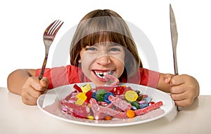 Child eating candy like crazy in sugar abuse and unhealthy sweet nutrition concept