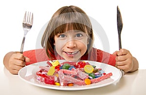 Child eating candy like crazy in sugar abuse and unhealthy sweet nutrition concept