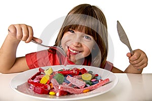 Child eating candy like crazy in sugar abuse and unhealthy sweet nutrition concept