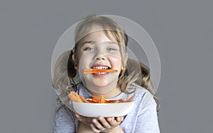 Child eating carrots. Healthy nutrition concept. Little kid eats vegetables. Caucasian girl poprtrait.