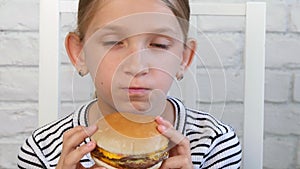 Child eating fast food, kid eats hamburger in restaurant, girl drinking juice