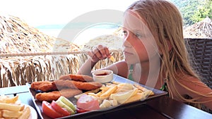 Child Eating Fast Food at Restaurant on Beach, Girl Eats Fries Fried Potatoes 4K