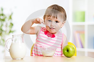Child eating food itself with spoon