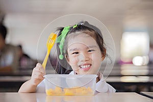 Child eating an fruit, lots of fresh fruit on the table in front as after school