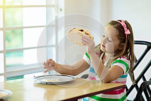 Child eating pancakes. Breakfast for kids.