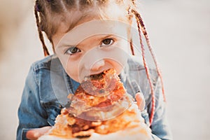 Child eating pizza. Fastfood for kids. Junkfood addiction. Italian cuisine. Children food. Childhood obesity. Tasty food