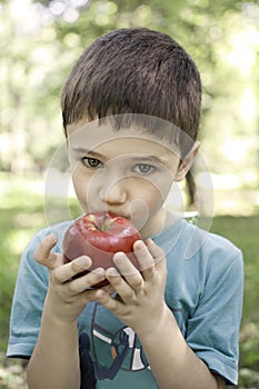 Child eating red apple