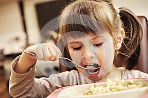 Child eating shaped pasta photo