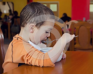 Child eating soup in restaurant