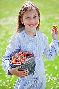 Child eating strawberries in a field