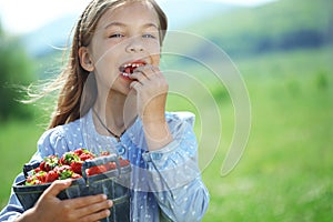 Child eating strawberries in a field