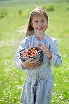 Child eating strawberries in a field