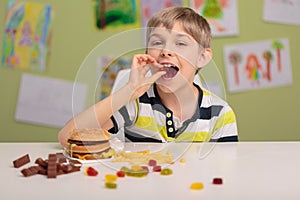 Child eating sweets and fastfood