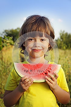 Child eating watermelon in the garden