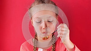 Child eating yogurt jelly pink background. Dairy product diet Lactobacillus Acidophilus, healthy homemade breakfast menu.