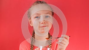 Child eating yogurt jelly on pink background. Dairy products kids diet, healthy homemade breakfast menu. Kids healthcare